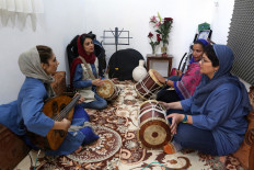 (L to R) Oud player Noushin Yousefzadeh, kasser drummer Negin Heydari, pippeh drummer Malihe Shahinzadeh, and drummer Faezeh Mohseni practise together at a home studio called the 'Dingo room' in Iran's southern Gulf port city of Bandar Abbas on April 30, 2019. 