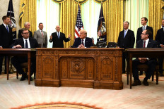US President Donald Trump (center), Kosovar Prime Minister Avdullah Hoti (right) and Serbian President Aleksandar Vucic (left) listen to US Vice President Mike Pence during a signing ceremony, in the Oval Office of the White House in Washington, DC, on September 4, 2020. 