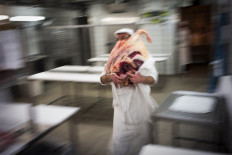 In this file photo taken on February 20, 2017 a teacher brings meat to butchers during the best apprentice butcher contest in Paris. 