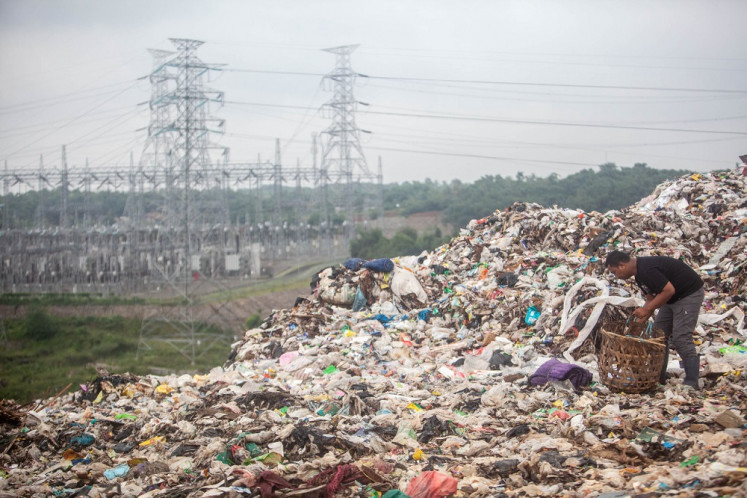 Plastic world: A scavenger collects plastic waste for recycling at Cipeucang dump site in Serpong, South Tangerang, west of Jakarta, on Feb. 28. Indonesia, like other countries, is intensifying the fight against plastic pollution. 