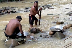Two miners pan for gold on July 7, 2020, along a stream near Korowai, Papua.