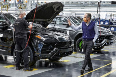 This photo taken and handout by Italian luxury sports car manufacturer Lamborghini on May 4, 2020 shows Lamborghini CEO Stefano Domenicali (right) waves to a worker on the assembly line as work resumes at the Lamborghini plant in Sant'Agata Bolognese, while Italy starts to ease its lockdown, during the country's lockdown aimed at curbing the spread of the COVID-19 infection, caused by the novel coronavirus.Domenicali is set to become the new CEO of Formula One after leaving the Italian team earlier than expected, media reports said Wednesday.