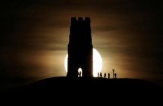 St Michael's Tower is seen on Glastonbury Tor as a full moon rises in Glastonbury, England, on January 10, 2020. 