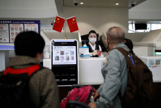 A staff member wearing a face mask following the coronavirus disease (COVID-19) outbreak attends to passengers at a check-in counter at the Beijing Daxing International Airport, ahead of Chinese National Day holiday, in Beijing, China September 25, 2020. 