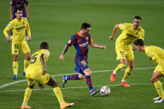 Barcelona's Argentinian forward Lionel Messi (C) runs with the ball during the Spanish league football match FC Barcelona against Villarreal CF at the Camp Nou stadium in Barcelona on Sept. 27, 2020. 