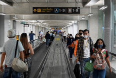 This photo taken on August 21, 2020 shows passengers wearing face masks as a preventive measure against the COVID-19 coronavirus walking along a concourse at the departure area of Suvarnabhumi airport in Bangkok.