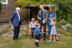 An handout photograph released by Kensington Palace on Sept 26 in London, shows Britain's Prince William, Duke of Cambridge, Britain's Catherine, Duchess of Cambridge, Prince George (seated), Princess Charlotte and Prince Louis with Sir David Attenborough (left) in the gardens of Kensington Palace in London after The Duke and Sir David attended an outdoor screening of Sir David's upcoming feature film.
