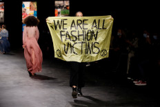 Extinction Rebellion protester walks runway at Dior in Paris