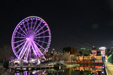 The Ferris Wheel of Montreal is seen on April 4, 2020, located in the tourist district of the Old Port, and illuminated in the colours of the rainbow in support of victims from the coronavirus, COVID-19, pandemic. 