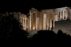 People are seen at the Propylea as the ancient Acropolis hill is illuminated with new revamped, detailed lighting system, after a ceremony in Athens, Greece, on September 30, 2020 