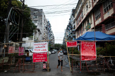 A woman walks a barricaded street amid the outbreak of the coronavirus disease (COVID-19), in Yangon, Myanmar, October 1, 2020. Picture taken October 1, 2020. 