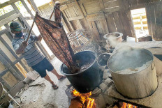 Handmade batik: Batik craftsman Sudarto dyes fabric in a cooking pot at a home industry in Imogiri, Yogyakarta, on Sunday. The hand-drawn batik on silk fabric was sold for Rp 2 million (US$134.55) or more.