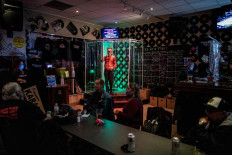 A man sings inside a makeshift 'shower stall', set up in order to protect patrons from the coronavirus disease (COVID-19) at Tracie's Place Restaurant and Karaoke in Hamilton, Ontario, Canada, on October 2, 2020. 