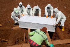 Laid to rest: Gravediggers lower a coffin of a COVID-19 victim at Pondok Ranggon public cemetery in East Jakarta on Monday.