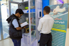A Yemeni man checks out a book from a mini-library, put in place by 'Yemen Reads' campaign, in the capital Sanaa on September 29, 2020.  