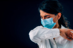 Is it possible to sneeze or cough into your elbow when wearing a mask? Apparently so, as scientists consider this to be the best way of preventing respiratory droplets from spreading through the air. 