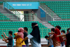 A Bekasi Public Order Agency (Satpol PP) officer watches over the morning exercises for asymptomatic COVID-19 patients isolating at the Patriot Candrabhaga Stadium isolation center in Bekasi, West Java, on October. 2. 2020. The stadium houses asymptomatic patients whose homes do not have sufficient space for self-isolation. JP/Dhoni Setiawan