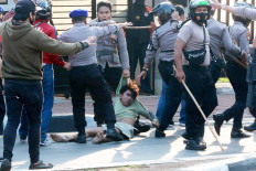 A group of police detain a demonstrator during a protest against the government's proposed labor reforms in the controversial omnibus bill on job creation.
