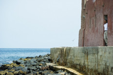 US President Barack Obama looks out from the Door of No Return while touring the House of Slaves, or Maison des Esclaves, at Goree Island off the coast of Dakar on June 27, 2013. 