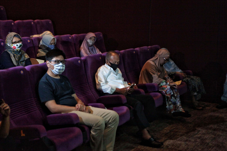 Cinema goers maintain social distance with one another during a simulation of the reopening of the XXI Cinema in Jakarta on Aug. 29.