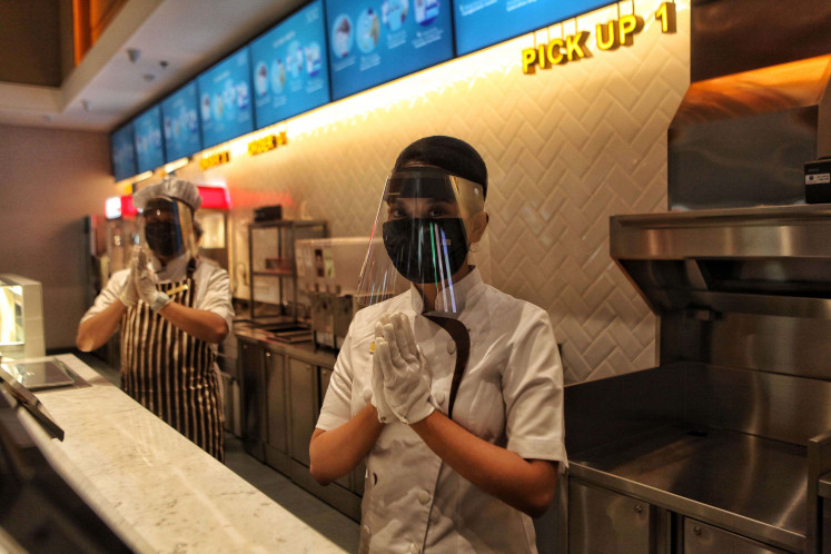 Cinema staffs wear face shields and masks during a simulation of the reopening of the XXI cinema in Jakarta on Aug. 29.