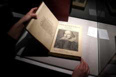 An employee of Christie's auctions holds a 1663 rare first folio of 36 Shakespeare works that was sold for a record 8.4 million dollars (9.978 million with buyers fee) in the Manhattan borough of New York City, New York, United States, ono October 14, 2020. 