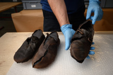 A picture taken on October 8, 2020 in Sion shows the hand of Pierre Yves Nicod, curator at archaeological department of the history museum of Canton of Valais showing a shoe from 17th century found in a glacier in the Southern Swiss Canton of Valais. 