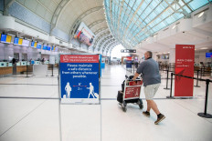 A man pushes a baggage cart wearing a mandatory face mask as a 'Healthy Airport' initiative is launched for travel, taking into account social distancing protocols to slow the spread of the coronavirus disease (COVID-19) at Toronto Pearson International Airport in Toronto, Ontario, Canada, on June 23, 2020. 