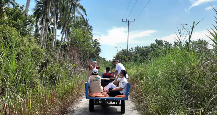 Doctor Laili Candrawati's team rides on a motorized tricycle to distribute COVID-19 information to villagers in the Hibala subdistrict of South Nias regency in North Sumatra. Medical workers in the region provide COVID-19 otherwise unavailable due to lacking access to electricity, television and the internet.