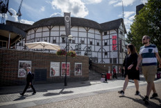 People walk past Shakespeare's Globe theater in central London on August 24, 2020.