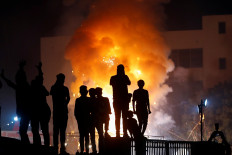 People watch as an effigy of demon king Ravana burns during Dussehra festival celebrations, amid the outbreak of the coronavirus disease (COVID-19), in New Delhi, India, on October 25, 2020. 