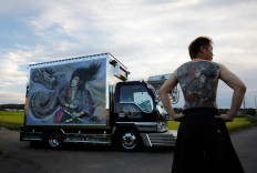 Truck driver Hideyuki Haga, 44, poses in front of his truck which is decorated with the same design as his tattoo on his back, in Hiki, Saitama, Japan, on September 3, 2020. 