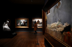 A visitor walks by the painting 'Last Dream of a Virgin' by Manuel Villegas Brieva during the exhibition 'Uninvited Guests. Episodes on Women, Ideology and the Visual Arts in Spain (1833-1931)' at El Prado museum in Madrid on October 23, 2020.