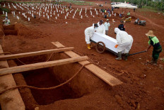 Gravediggers at the Pondok Ranggon public cemetery in East Jakarta carry a coffin using a cart on Oct. 19. The COVID-19 cemetery is predicted to run out of burial space by the end of the month. JP/P.J.Leo