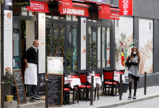 A waiter waits for customers before the national lockdown introduced as part of the new COVID-19 measures to fight a second wave of the coronavirus disease, in Paris, France, October 29, 2020.   