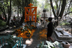 A woman walks past a decorated grave of a person at the Xilotepec cemetery in the lead-up to the Day of the Dead celebration, in Xochimilco on the outskirts of Mexico City, Mexico, on October 28, 2020. 