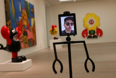 Philip Colbert uses one of the robots that allow viewers to interactively engage with his Lobsteropolis exhibition at a preview event at the Saatchi Gallery in London, Britain, on October 28, 2020. 