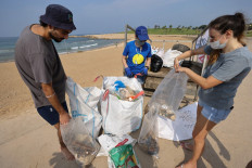 Israeli volunteers take part in a mass beach clean up during a one-day operation launched by some 20 Israeli associations to 'beat the world record' for beach cleaning, on the shore of the the central city of Tel Aviv on October 30, 2020. 