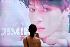 A woman takes a picture of a billboard wishing happy birthday to a K-pop singer Jimin at the subway in Bangkok, Thailand, on November 2, 2020. 