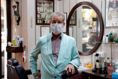 Barber Luigi Pinzo, 80, poses for a photo two days before closing his hairdresser salon after 60 years because of fewer clients and fear of the coronavirus disease (COVID-19), in Rome, Italy, on October 29, 2020. 