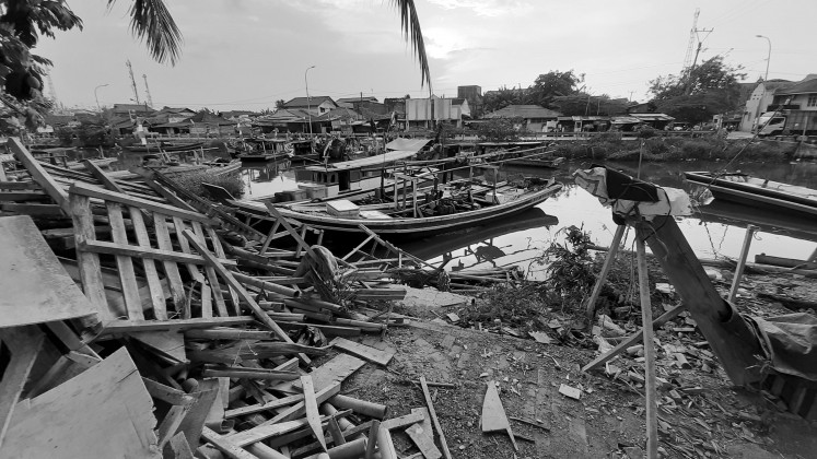 Shell of its former self: Surrounded by piles of garbage, fishing boats are seen docked at Karangantu Port in Serang, Banten.
