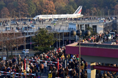 Spectators watch an Air France plane bound for Paris' Charles de Gaulle (CDG) Airport driving to the runway before the last take-off from Berlin Tegel Airport, in Berlin, Germany, on November 8, 2020. 