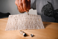 A man shows on November 8, 2020, in Munster, eastern France, a message probably lost by a carrier pigeon in 1910, sent by a German officer and miraculously resurfaced in 2020 in Alsace where it was found by chance.