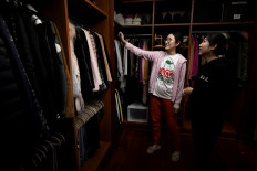 This photo taken on October 26, 2020, shows client Chen Rui (left) talking to a home organizer after arranging her luxury wardrobe at her residence in Beijing.