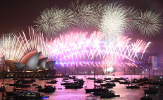 New Year's Eve fireworks erupt over Sydney's iconic Harbour Bridge and Opera House (left) during the fireworks show on January 1, 2020.