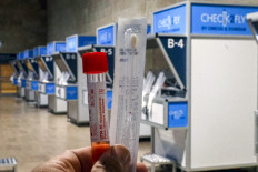 A person holds a COVID-19 coronavirus swab testing kit before sampling booths at the newly-inaugurated coronavirus rapid testing center at Israel's Ben Gurion International Airport in Lod on November 9, 2020. 