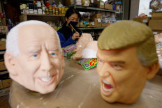 A worker of Ogawa Studios, a mask and toy making company, works next to masks depicting US President Donald Trump and US President-elect Joe Biden after Biden was called winner of the presidential election, at its studio in Saitama, Japan, on November 12, 2020. 