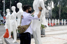 An activist installs mannequins at the Hotel Indonesia traffic circle to commemorate the 2020 World Day of Remembrance for Road Traffic Victims on Nov. 15.