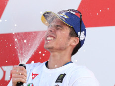 Suzuki Ecstar's Joan Mir celebrates with sparkling wine on the podium after winning the world championship held at Circuit Ricardo Tormo, Valencia, Spain on Sunday.
