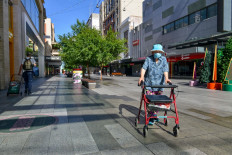 A woman walks in a street in Adelaide during day one of total lockdown across the state on November 18, 2020.  day one of total lockdown across the state on November 18, 2020. 